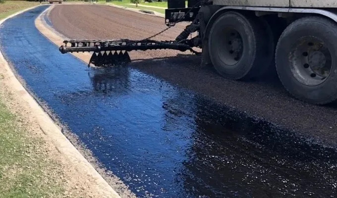 Bitumen spray seal being applied over a prepared road base