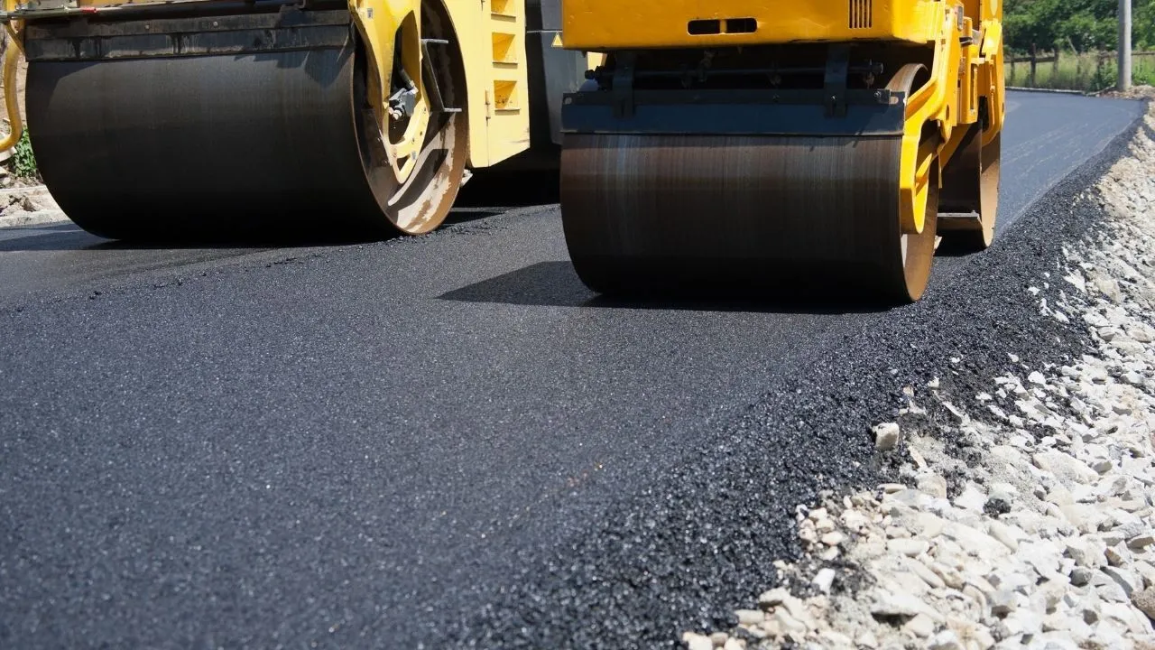 A roller compacting a freshly laid asphalt driveway