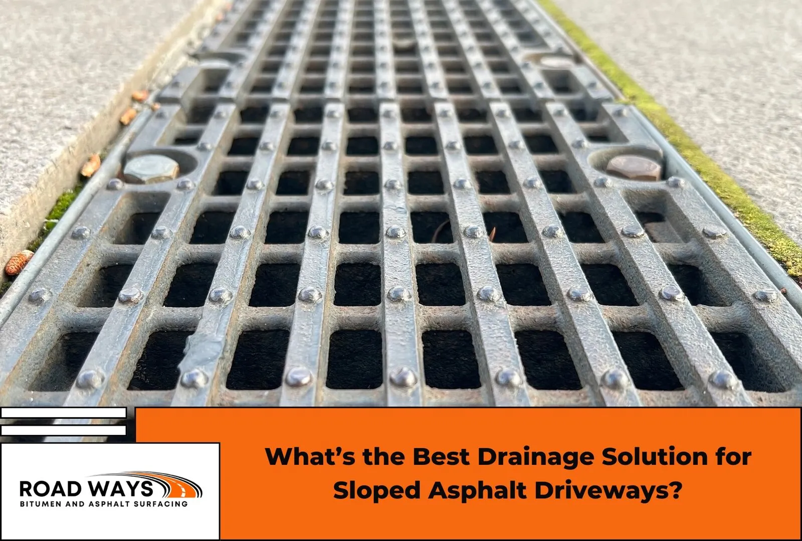 A sloped asphalt driveway with a channel drain across the base